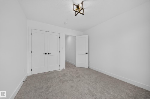 Neutral tone carpeted room with white walls, baseboards, and trim - 803 30 Avenue, Edmonton, AB 