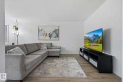 Open concept living area featuring wood-finish flooring and light-toned walls - 