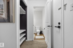 Powder room featuring chevron-patterned wallpaper and wood-finish flooring - 