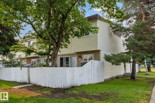 Multi-level residence featuring light-colored siding and a contrasting dark roofline - 105 16428 109 Street, Edmonton, AB 