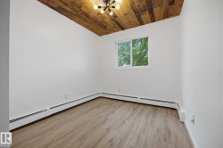 Room featuring a wood-panel ceiling and wood-finish flooring - 