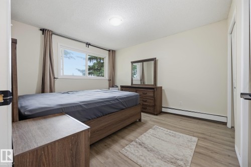 Bright room featuring wood-finish flooring and a white baseboard - 105 16428 109 Street, Edmonton, AB 