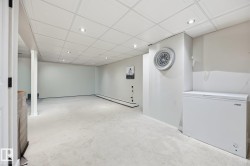 Spacious interior room featuring light-colored carpeting, recessed lighting, and a drop ceiling - 