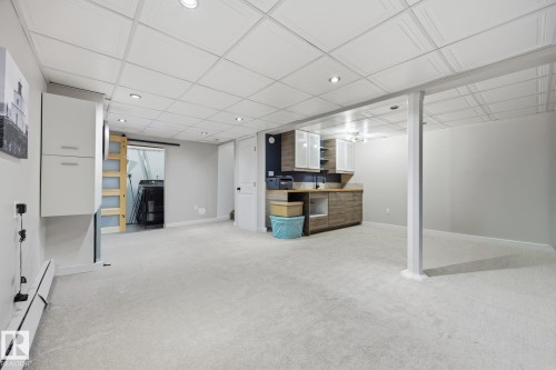 Spacious lower-level area featuring light-toned carpeting, recessed lighting, and a drop ceiling - 105 16428 109 Street, Edmonton, AB 