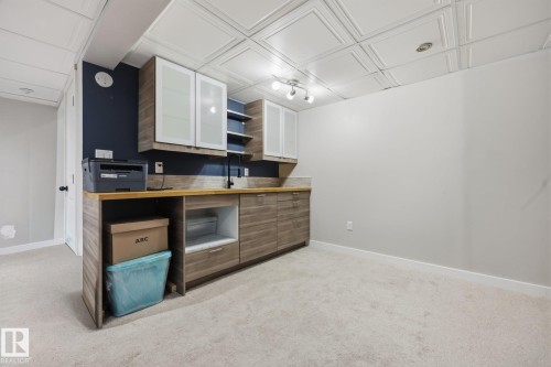 Built-in cabinetry with wood-finish countertops and integrated sink - 105 16428 109 Street, Edmonton, AB 