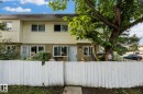 Two-story multi-unit dwelling with light-colored siding and a brown roofline - 105 16428 109 Street, Edmonton, AB 