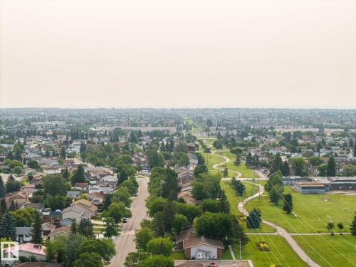 Expansive aerial perspective showcasing a residential area with numerous houses featuring various roof styles - 105 16428 109 Street, Edmonton, AB 