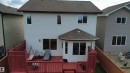 Rear elevation featuring light-colored siding, a multi-level red-stained deck, and a hexagonal sunroom with a shingled roof - 1216 37C Avenue Nw, Edmonton, AB  - Outdoor With Exterior 