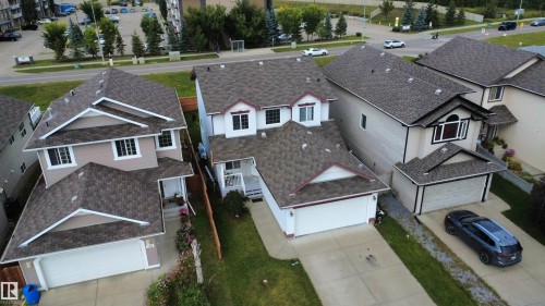 Two-story detached residence featuring a white facade with red trim accents, an attached two-car garage, and a covered front entry - 1216 37C Avenue Nw, Edmonton, AB - Outdoor