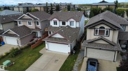 Contemporary two-story residence with attached double garage, featuring a peaked roofline and dormer windows - 