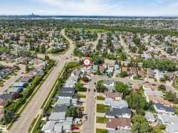 Aerial perspective showcasing a residential neighborhood with tree-lined streets and a distant city skyline - 