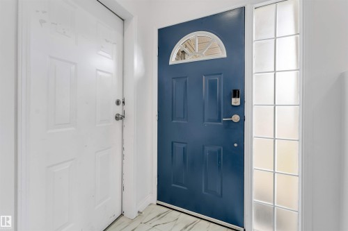Navy blue entry door with an arched transom window and a digital lock - 3332 43 Street, Edmonton, AB 