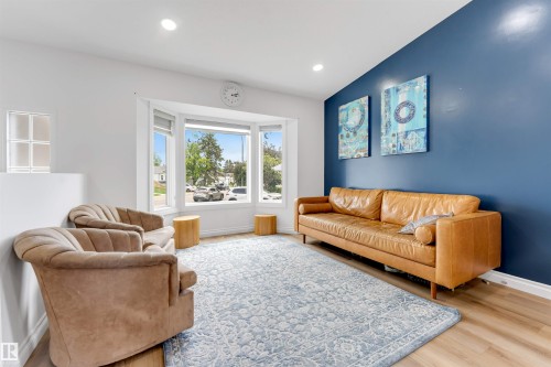 Living area featuring a bay window, recessed lighting, and wood-finish flooring - 3332 43 Street, Edmonton, AB 