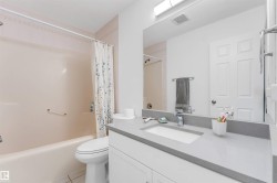 Bathroom featuring a white vanity with a gray countertop, integrated sink, and modern faucet - 