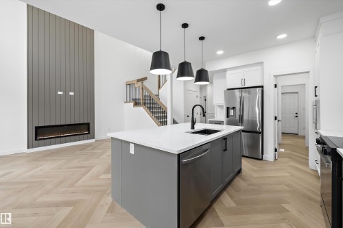 Open-concept living space with herringbone wood-finish flooring - 917 Elderberry Landing, Edmonton, AB 