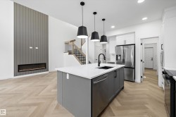 Open-concept living space with herringbone wood-finish flooring - 