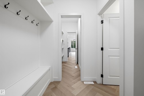 Entryway with custom built-in bench and storage shelf featuring matte black hooks - 917 Elderberry Landing, Edmonton, AB 