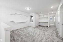 Carpeted room with a built-in desk and shelving - 