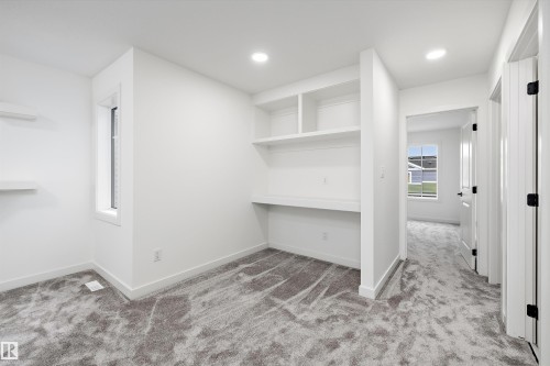 Room featuring built-in shelving and desk space, recessed lighting, and a neutral carpet - 917 Elderberry Landing, Edmonton, AB 