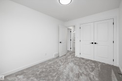 Room featuring light gray patterned carpeting, white painted walls, and white trim - 