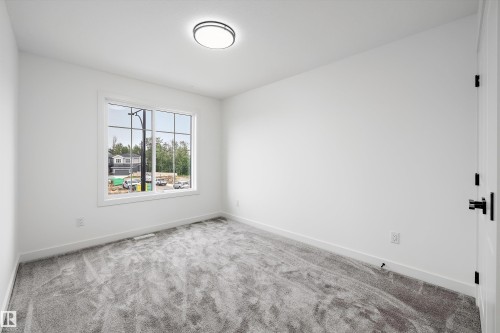 Spacious room featuring neutral carpeting and white painted walls - 917 Elderberry Landing, Edmonton, AB 
