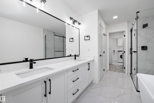 Double vanity featuring white cabinetry, quartz countertops, and matte black fixtures - 917 Elderberry Landing, Edmonton, AB 