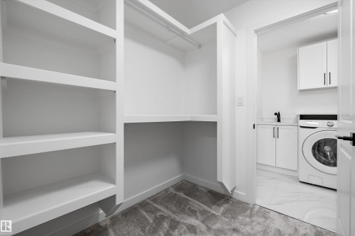 Custom built-in white shelving and hanging rod with grey carpet flooring - 917 Elderberry Landing, Edmonton, AB 