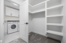 Dedicated laundry area with white cabinetry and a built-in countertop - 