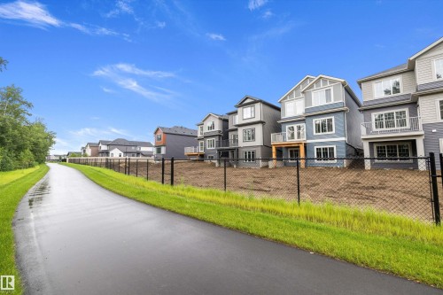 Modern residential development featuring multi-story homes with varied siding colors and private balconies - 917 Elderberry Landing, Edmonton, AB 