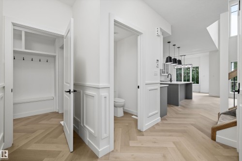 Herringbone wood-finish flooring extending through the entry and main living area - 917 Elderberry Landing, Edmonton, AB 