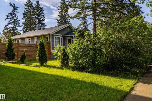 Single-story residence featuring grey siding, white trim, and a dark shingled roof - 11238 123 Street, Edmonton, AB 