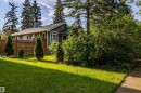Single-story residence featuring grey siding, white trim, and a dark shingled roof - 11238 123 Street, Edmonton, AB 
