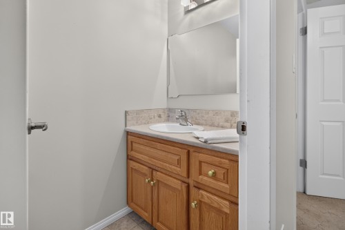 Bathroom vanity featuring a light wood cabinet, undermount sink, and light-toned countertop - 17603 85 Avenue Nw, Edmonton, AB 