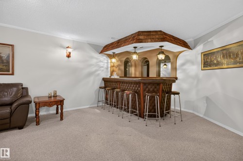 Built-in bar featuring a tufted facade, arched openings, and three pendant lights - 17603 85 Avenue Nw, Edmonton, AB 