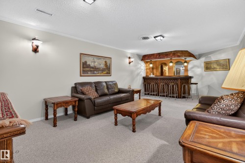 Recreation room featuring a built-in bar with pendant lighting, arched detailing, and a shingled canopy - 17603 85 Avenue Nw, Edmonton, AB 