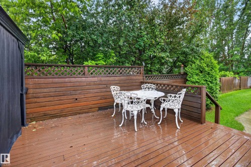 Spacious wood-finish deck featuring a full-height privacy wall with lattice accents - 17603 85 Avenue Nw, Edmonton, AB 