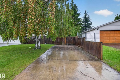 Paved driveway leading to a garage with a wood-look door - 17603 85 Avenue Nw, Edmonton, AB 