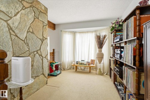 Stone accent wall with exposed wood beam and light-toned carpeting - 59 Patterson Crescent, St. Albert, AB - Indoor