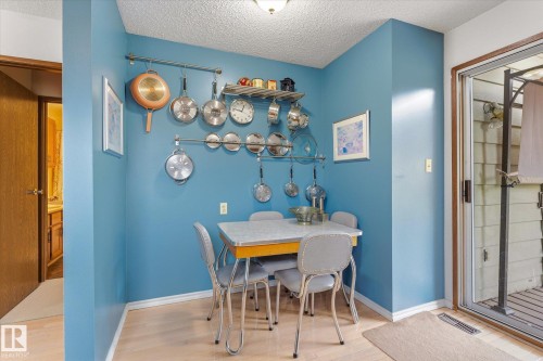 Kitchenette area featuring light wood-finish flooring, a pot rack system, and a sliding glass door - 59 Patterson Crescent, St. Albert, AB - Indoor Photo Showing Dining Room