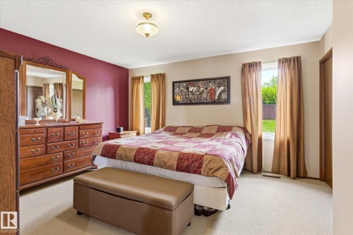 Carpeted room with a ceiling-mounted light fixture, two windows, and a built-in closet - 59 Patterson Crescent, St. Albert, AB - Indoor Photo Showing Bedroom