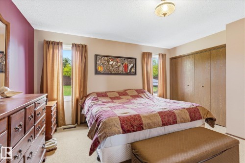 Bedroom featuring two windows, neutral walls with a single accent wall, and a ceiling-mounted light fixture - 59 Patterson Crescent, St. Albert, AB - Indoor Photo Showing Bedroom