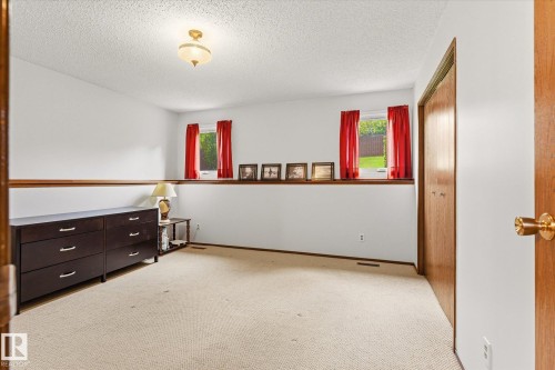 Carpeted interior space featuring white walls and a wood half-wall trim - 59 Patterson Crescent, St. Albert, AB - Indoor