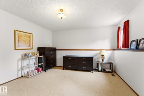 Carpeted interior space featuring white walls and a wood-finish chair rail - 59 Patterson Crescent, St. Albert, AB - Indoor