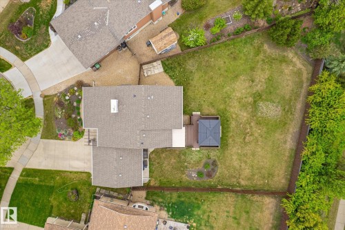 Expansive backyard featuring a manicured lawn, a brown privacy fence, mature perimeter trees, an elevated wood deck, and a detached gazebo with a dark roof - 59 Patterson Crescent, St. Albert, AB - Outdoor
