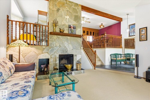 Stone-clad fireplace with hearth, wood mantel, and built-in wood-burning insert - 59 Patterson Crescent, St. Albert, AB - Indoor With Fireplace