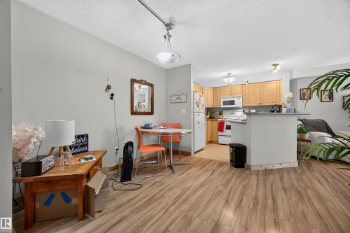 Open-concept living area with wood-finish flooring - 414 11214 80 Street, Edmonton, AB 