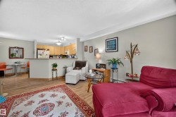 Open-concept living space featuring wood-finish flooring, light grey walls, and recessed lighting - 