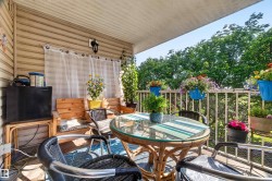 Covered balcony featuring vinyl siding, a metal railing, and a wall-mounted light fixture - 