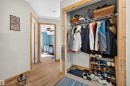 Hallway featuring wood-finish flooring, natural wood door frames, and a built-in closet with wire shelving - 414 11214 80 Street, Edmonton, AB 