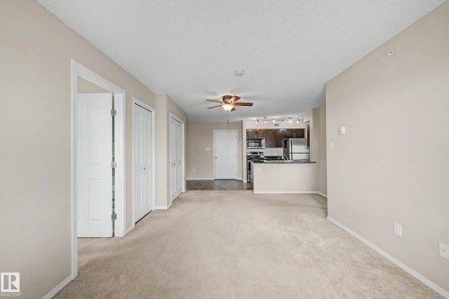 Open concept living area featuring neutral carpeting and a ceiling fan - 404 1080 Mcconachie Boulevard, Edmonton, AB 